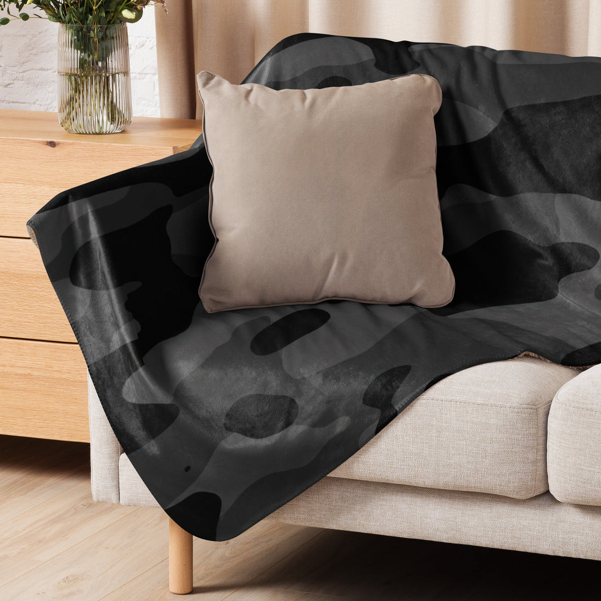 Black camo blanket black and gray camouflage fleece blanket draped over beige sofa for cozy home use