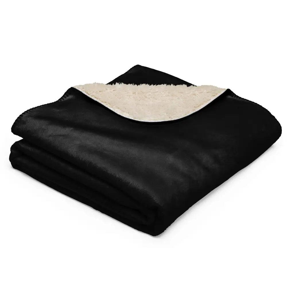 Black sherpa blanket featuring a black plush exterior and soft cream colored sherpa lining for cozy warmth