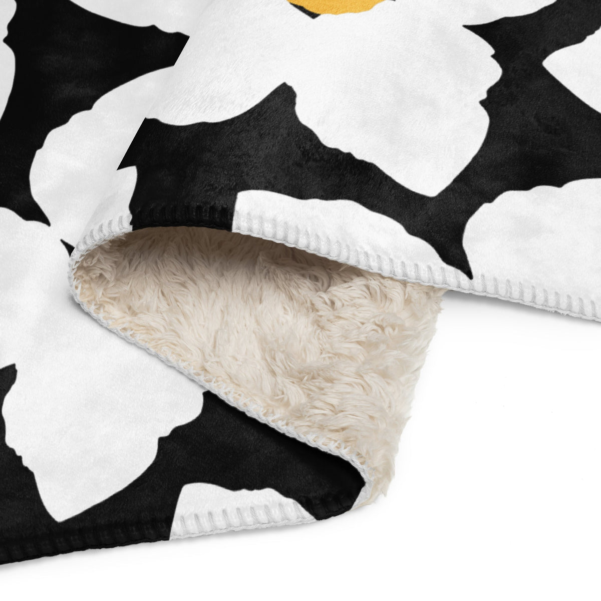 Black and white floral blanket featuring a fleece exterior with a soft cream-colored sherpa lining for warmth