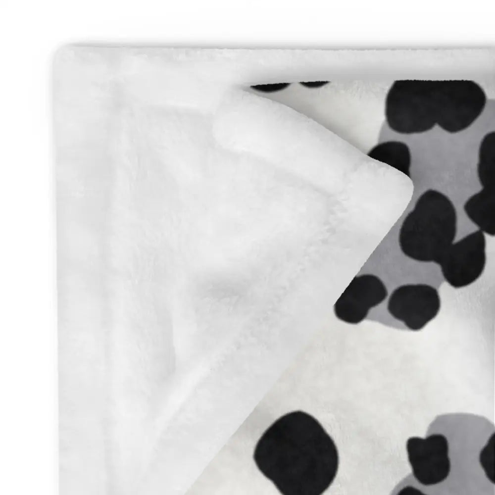 White plush blanket with black and gray cow print pattern in black and white leopard print blanket design