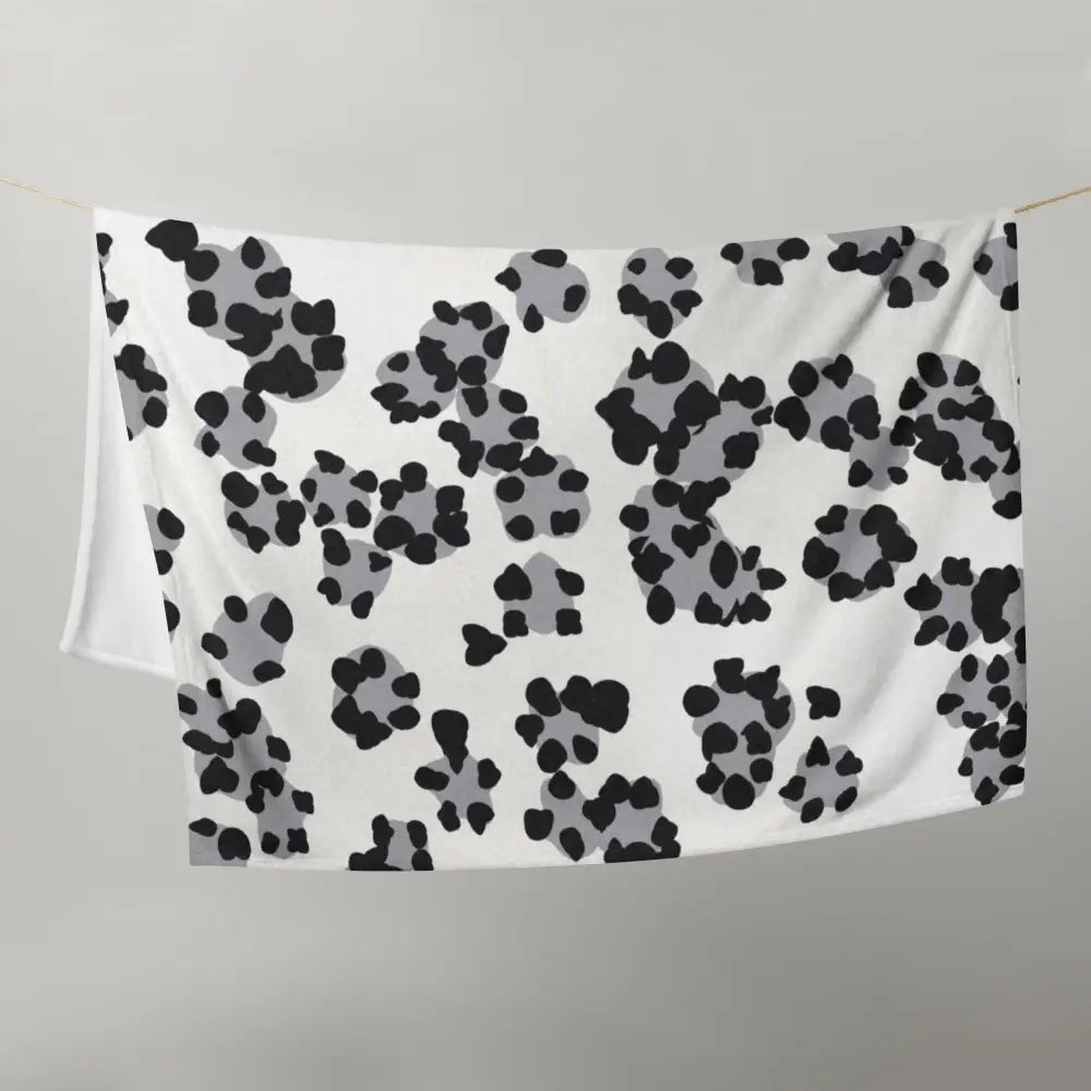 White blanket with black and gray paw print pattern matching the black and white leopard print blanket design