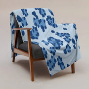 Une couverture bleue léopard en tissu doux bleu clair avec un motif abstrait bleu foncé sur une chaise en bois