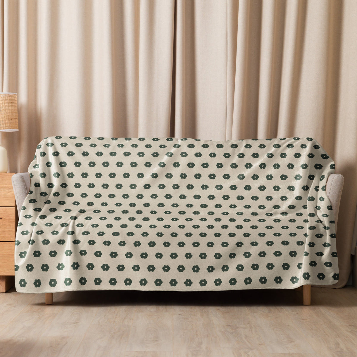 A soft cream-colored boho floral blanket with dark green small flower motifs for cozy home decor
