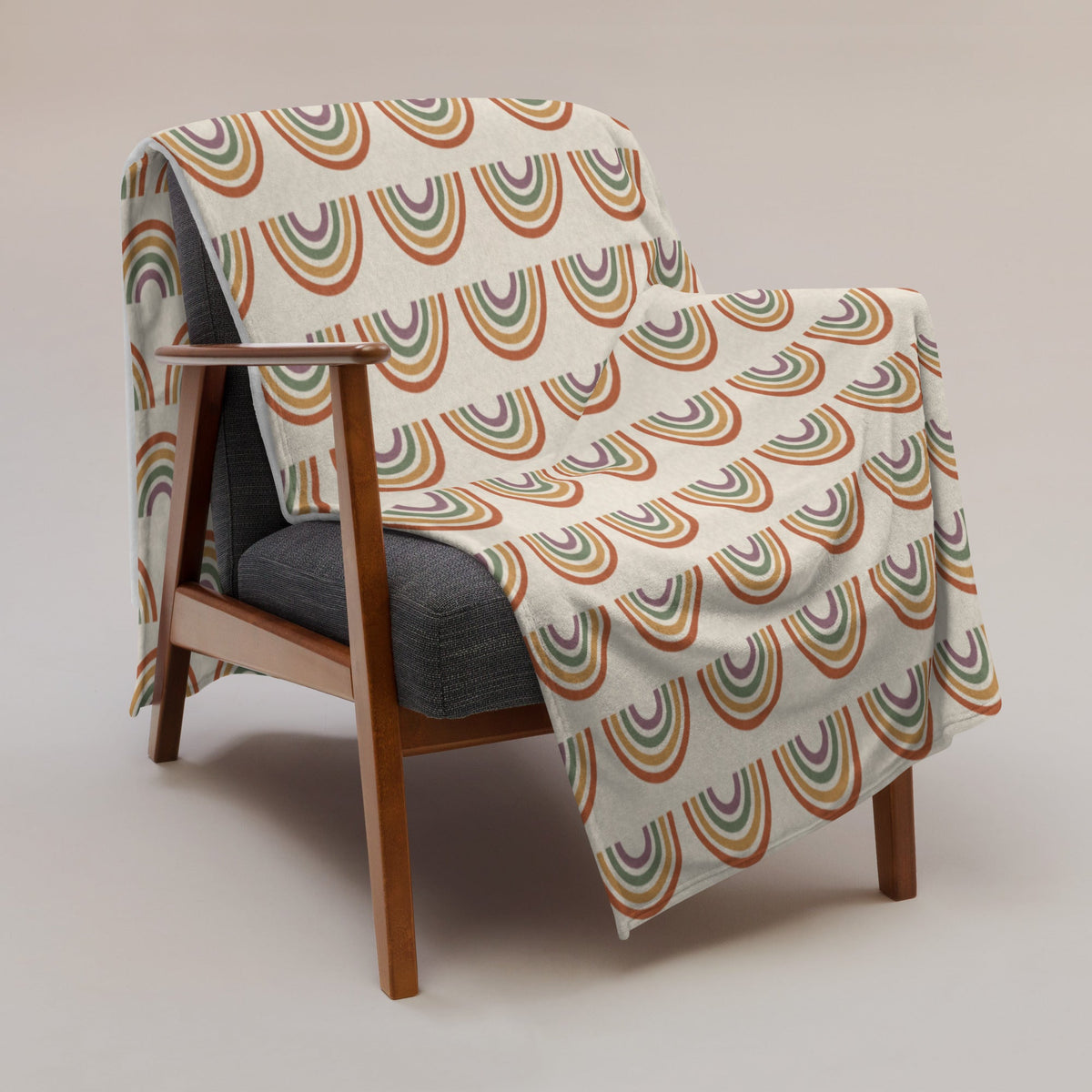 A cozy cream-colored boho rainbow throw blanket with vintage-style terracotta olive green and mustard yellow rainbows