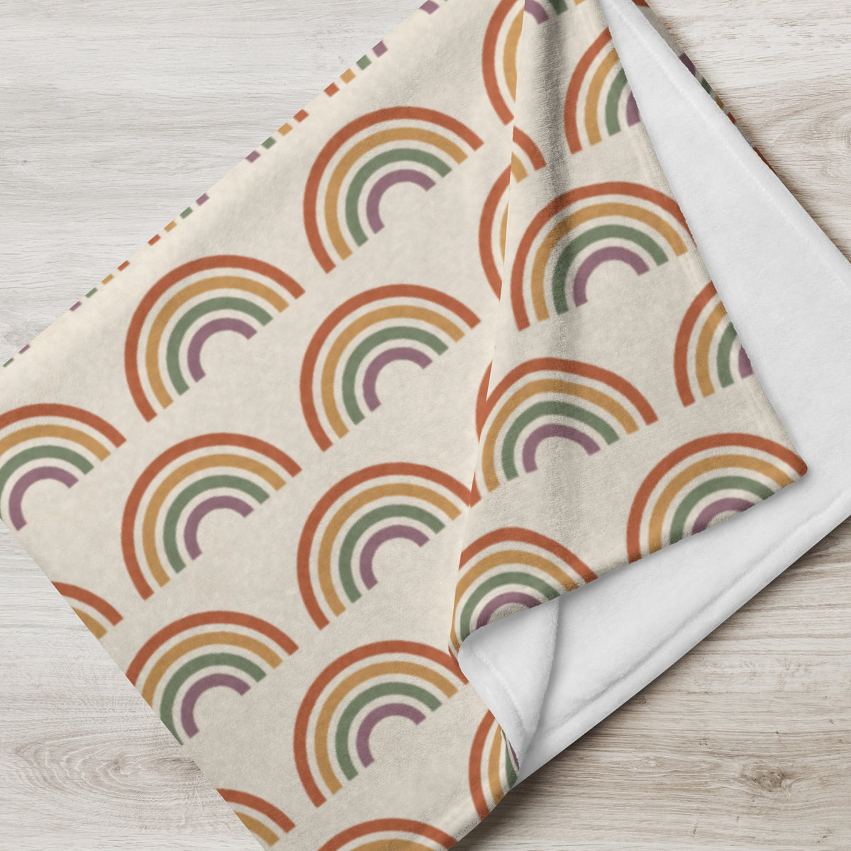 Boho rainbow throw blanket in soft cream with vintage rainbow pattern and plush white interior for cozy warmth