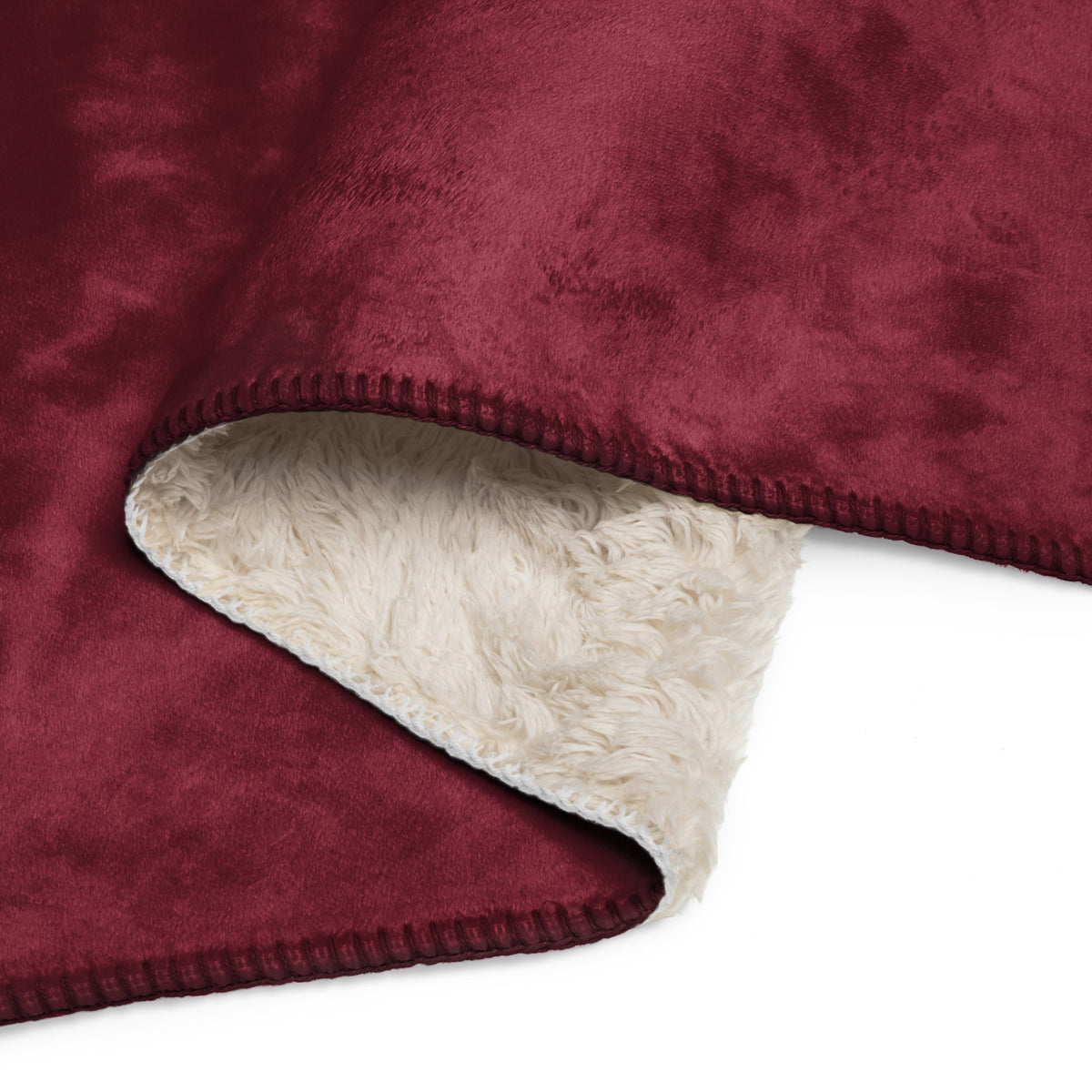 A plush burgundy sherpa blanket with soft white sherpa lining and neatly stitched edges for cozy warmth