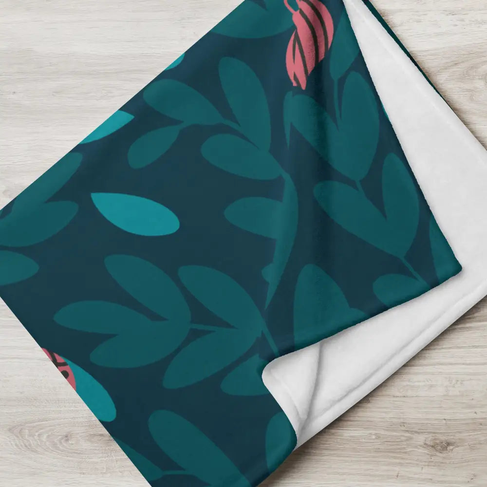 A cozy christmas ornament blanket with modern teal and pink botanical print and soft white fleece lining