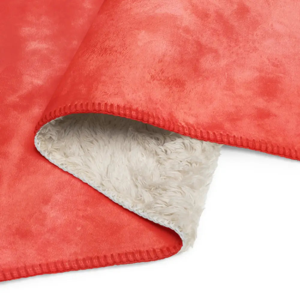 Coral sherpa blanket made of plush coral fleece with a soft fluffy white interior lining for cozy warmth