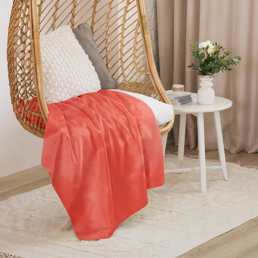 Coral sherpa blanket coral-colored faux leather throw blanket draped over a wicker hanging chair