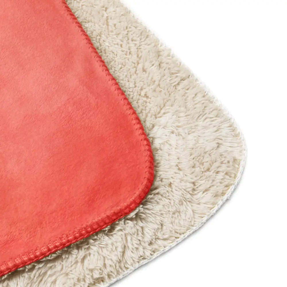 Coral sherpa blanket with coral-colored plush textured surface and contrasting cream fleece backing for warmth and comfort