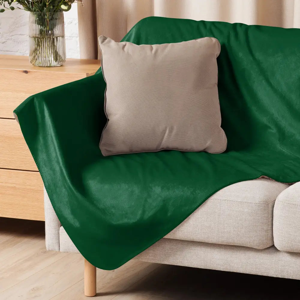 Housse de canapé en velours vert foncé drapée sur canapé clair avec coussin beige et couverture sherpa vert foncé