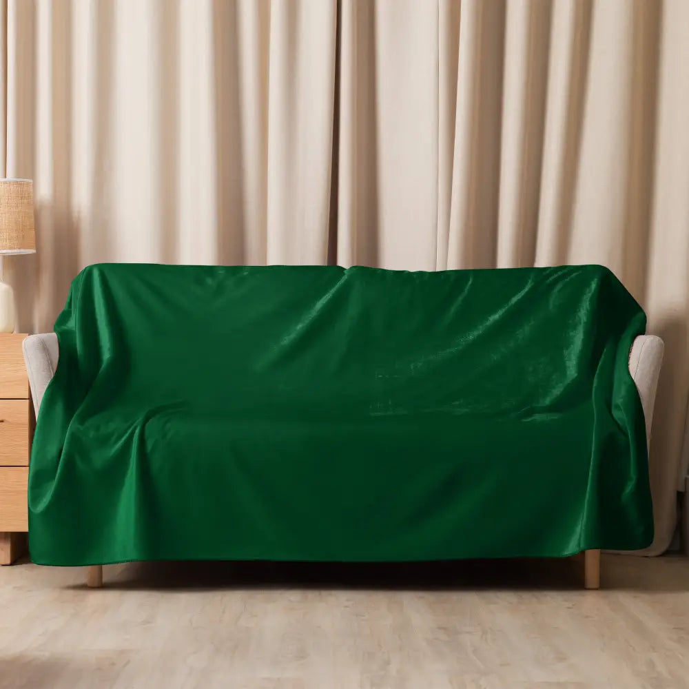 Housse de canapé en velours vert foncé drapée sur un canapé clair dans une couverture sherpa vert foncé