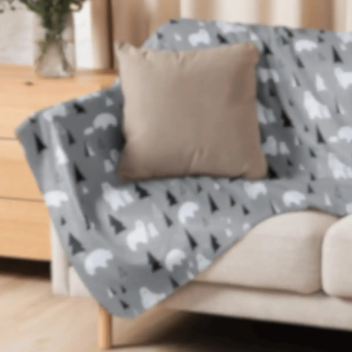 Gray throw blanket with a pattern of white polar bears and black pine trees.