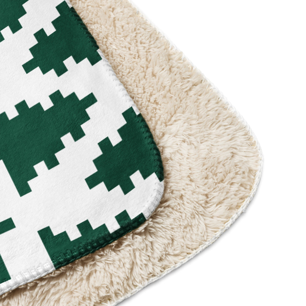 A cozy cream sherpa blanket with a bold green and white pixelated geometric pattern for Christmas use