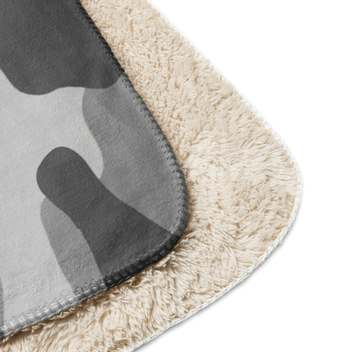 Cream-colored plush sherpa blanket with gray camouflage pattern on top surface for cozy warmth and style