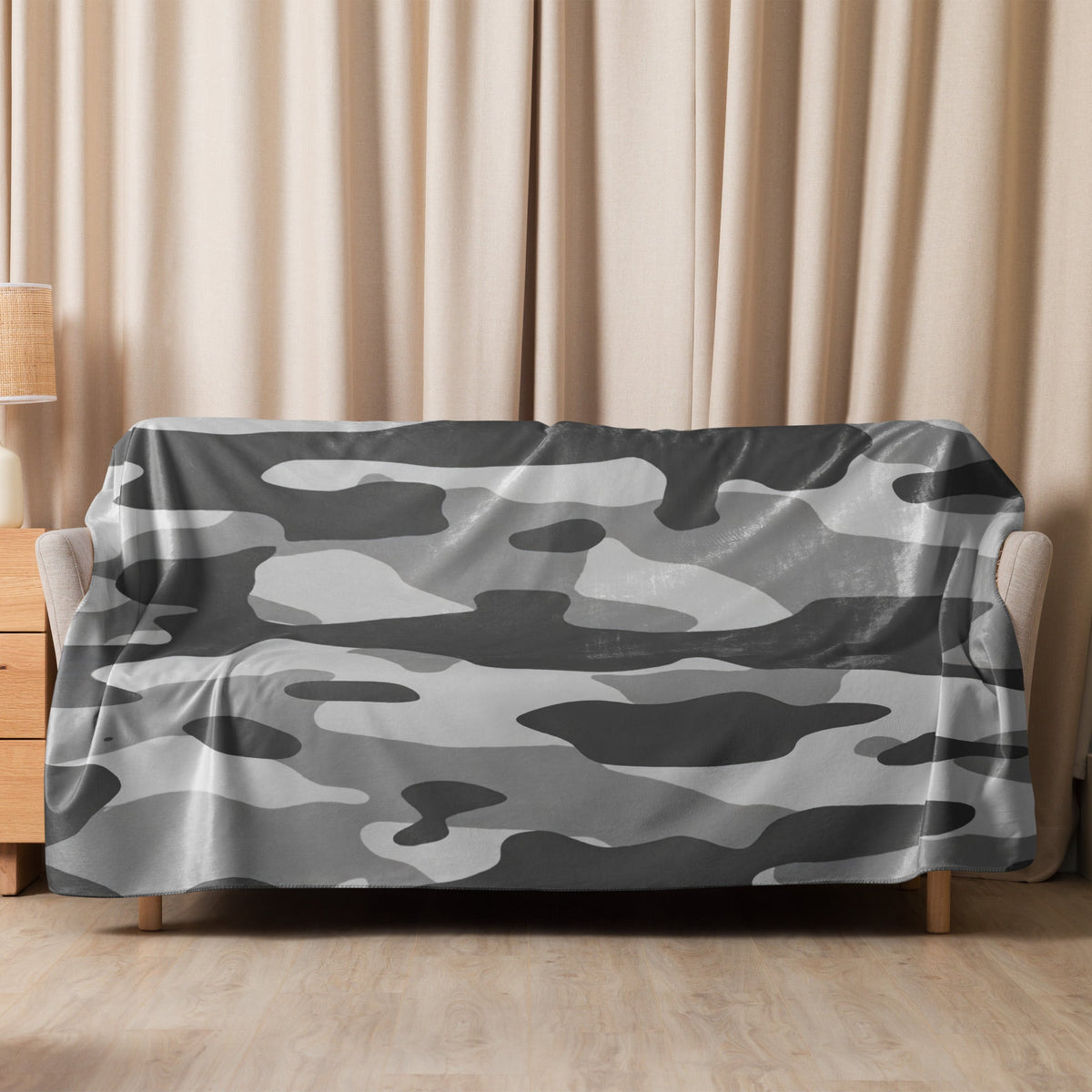 Gray and white camouflage patterned blanket draped over a sofa showcasing the grey camo blanket design