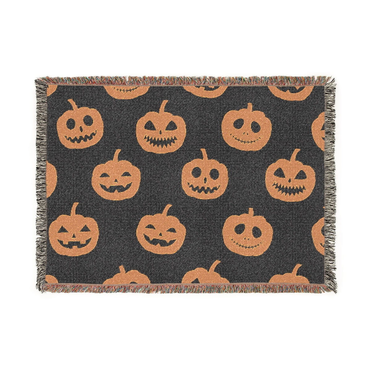 Black woven Halloween blanket with orange jack-o-lantern faces and fringed edges perfect for autumn decor