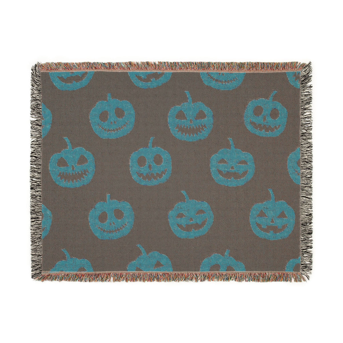 A dark gray woven Halloween throw blanket with teal jack o lantern faces and multicolored fringe edges