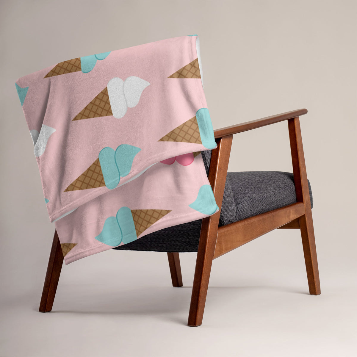 A soft pink ice cream cone blanket with playful cartoon waffle cone patterns and white light blue scoops