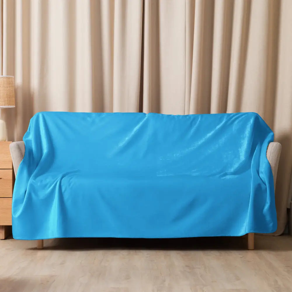 Bright blue satin sofa cover shown with light blue sherpa blanket for cozy and stylish home decor use