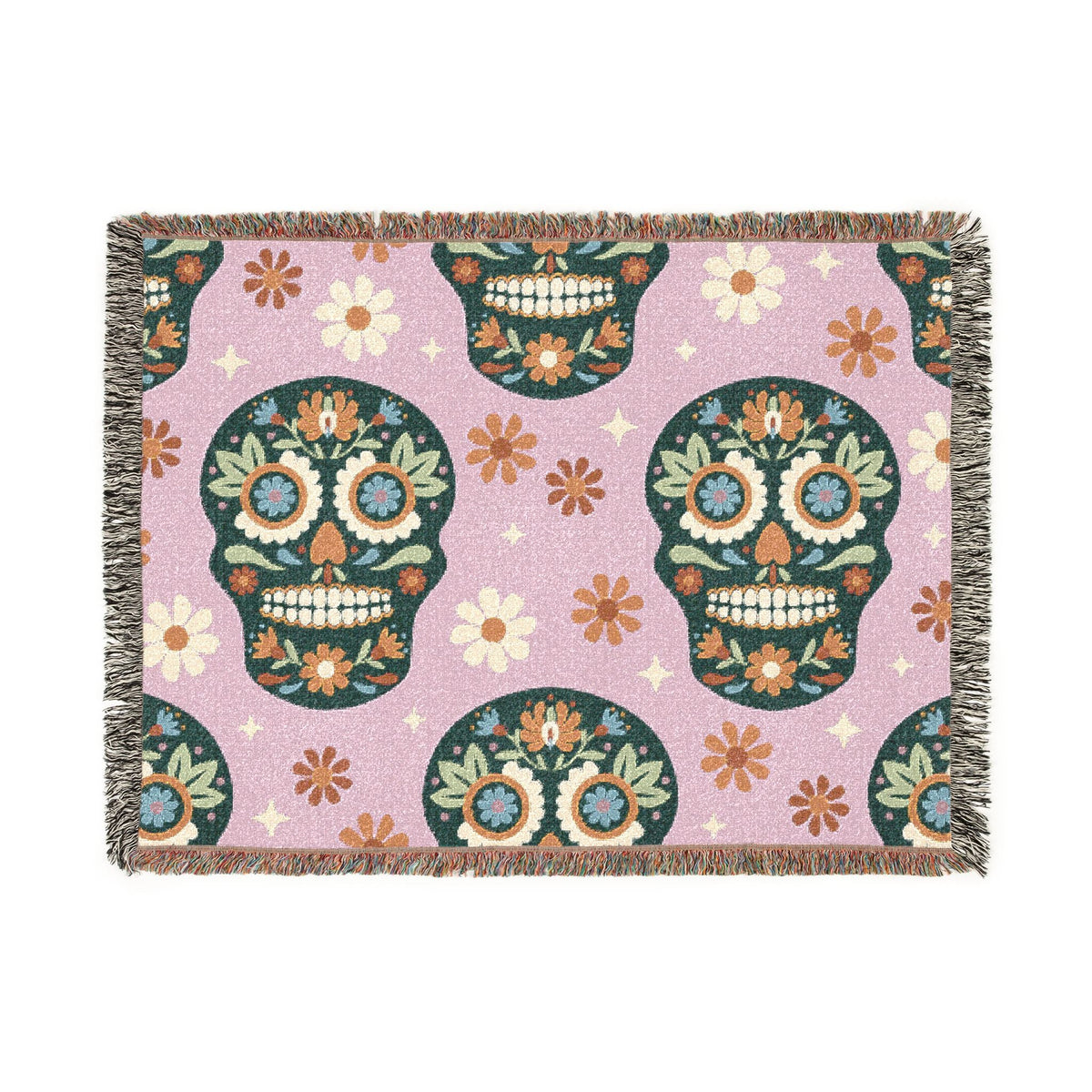 A pink Mexican woven blanket with colorful sugar skull patterns, flowers, stars, and fringed edges