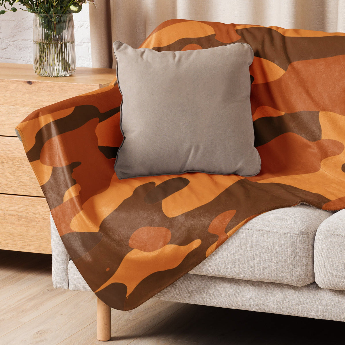 Orange camo blanket featuring orange and brown camouflage pattern draped over a sofa for cozy use