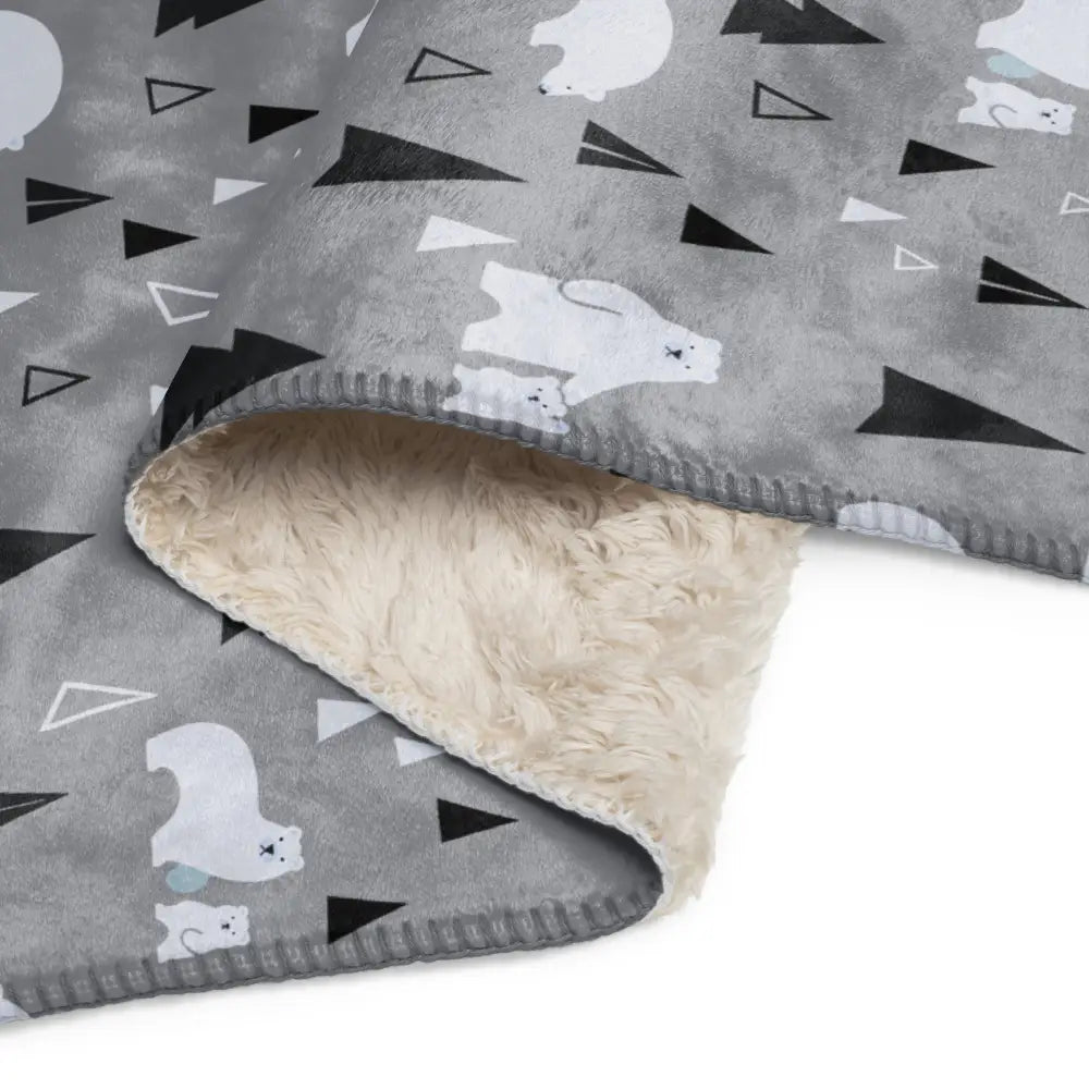 Gray polar bear sherpa blanket with white and black triangle patterns and plush cream sherpa lining for warmth