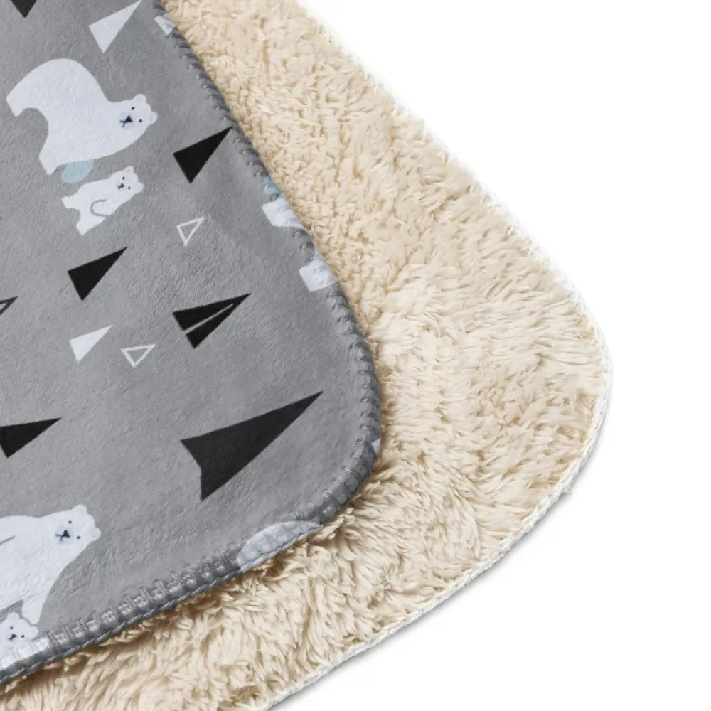 Gray polar bear sherpa blanket with white and black triangle fleece exterior and soft beige sherpa lining