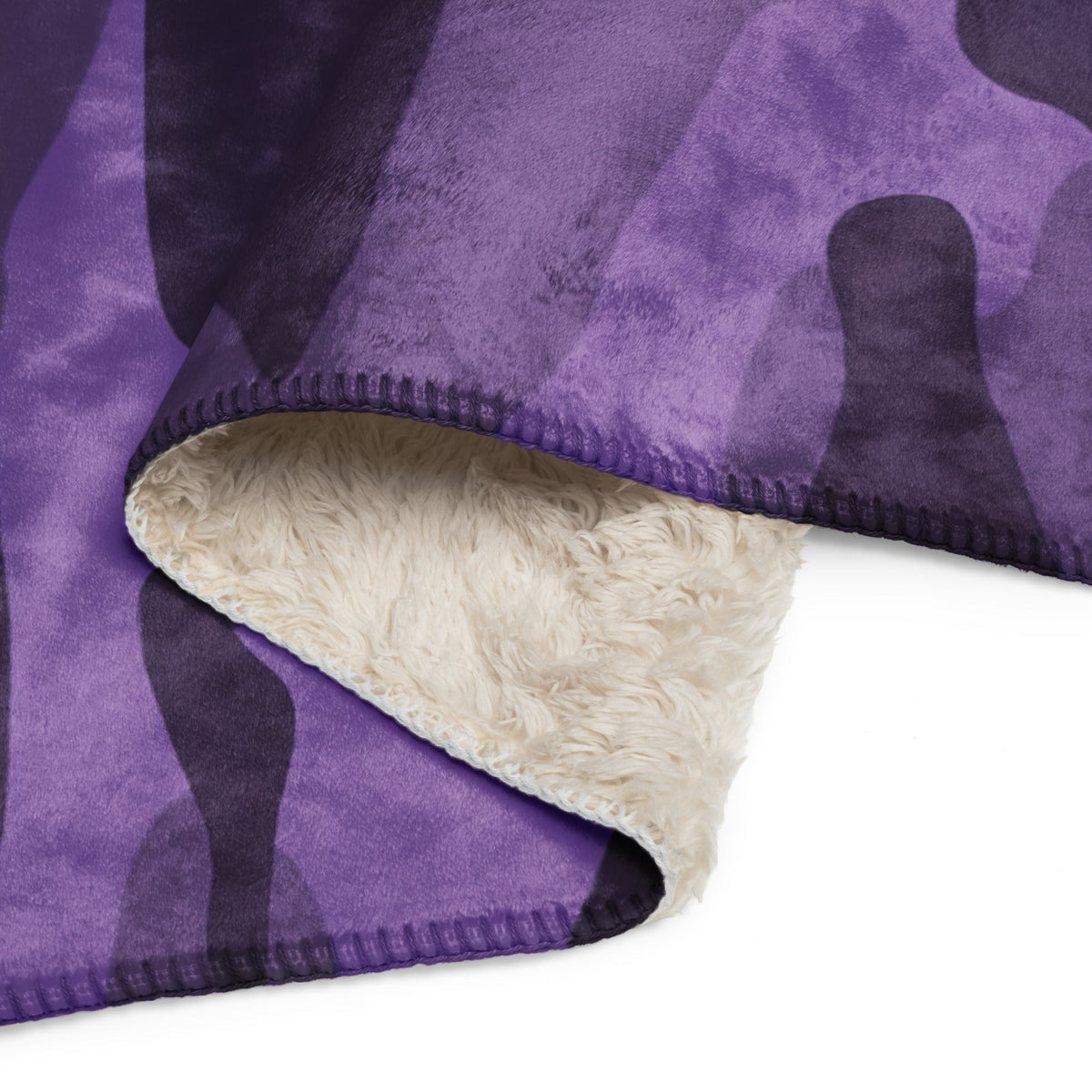 Purple camo throw blanket with purple and black fleece camouflage pattern and cream-colored sherpa lining