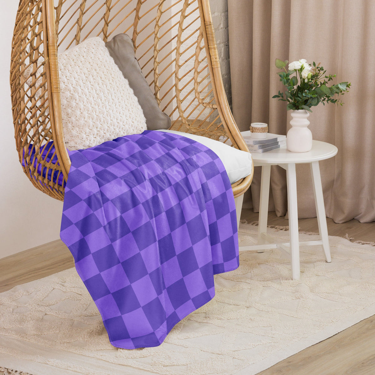 Purple checkered blanket with dark purple checkerboard pattern draped over a wicker hanging chair