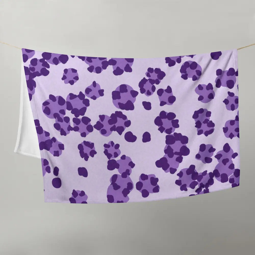 A soft lavender purple leopard print blanket with dark purple paw prints scattered across its surface