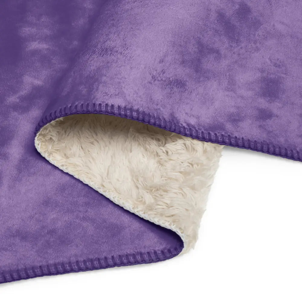Purple sherpa throw blanket with soft cream fleece interior and neatly stitched edges for cozy warmth