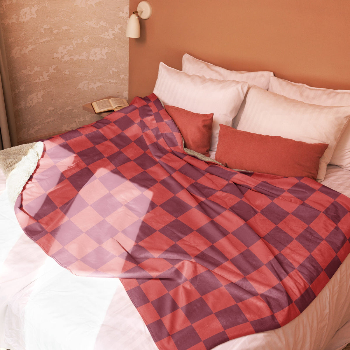 A red and purple checkered clanket with soft shiny fabric draped over a bed for cozy warmth and style