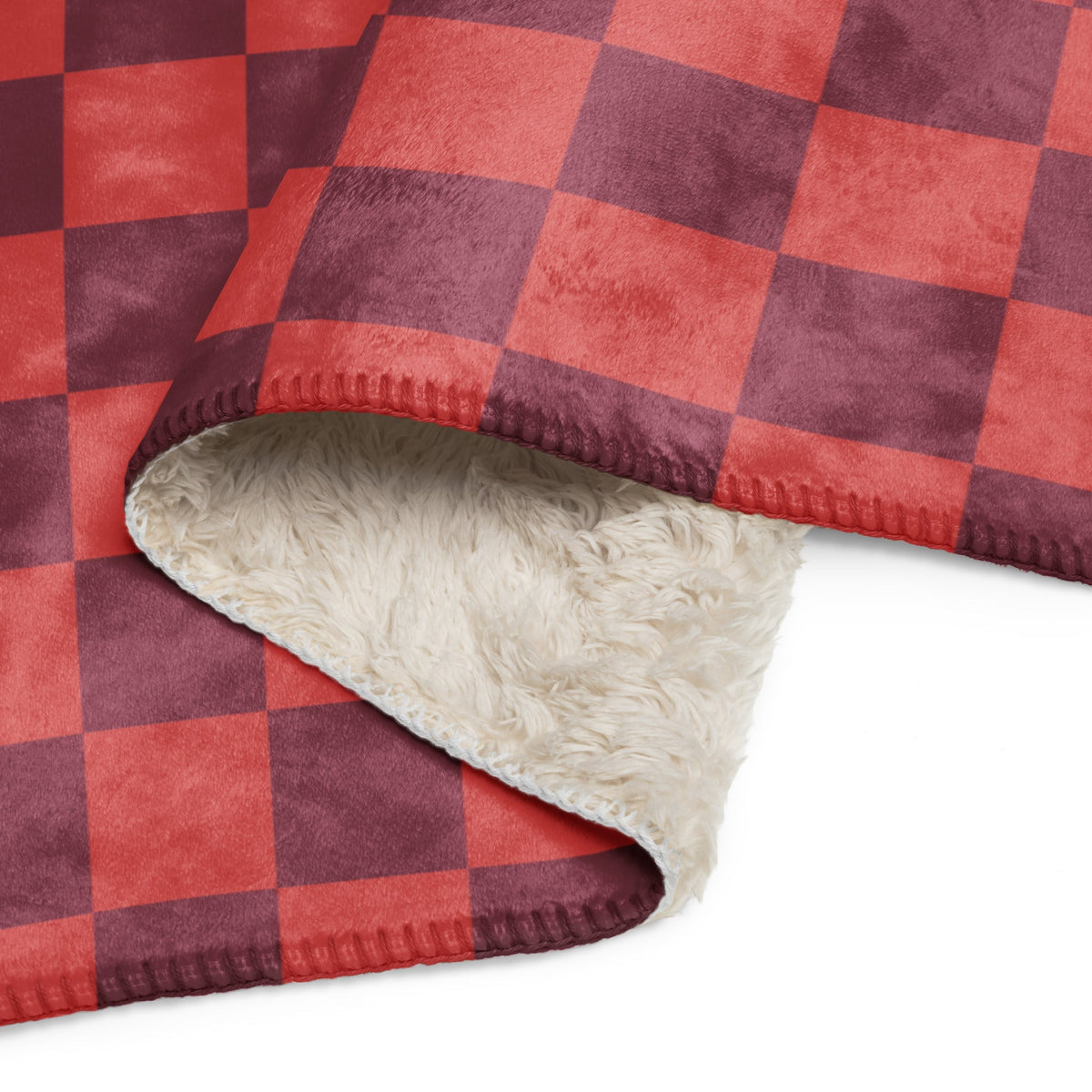 Red checkered clanket with red and maroon plaid exterior and plush cream-colored fleece interior for warmth and comfort