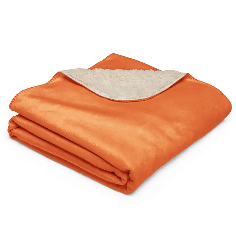 Orange sherpa blanket with soft cream-colored sherpa lining for warmth and comfort