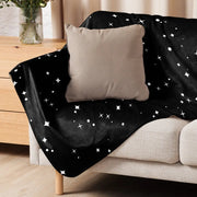 Star sherpa blanket black with white stars and dots draped over beige couch soft warm cozy throw