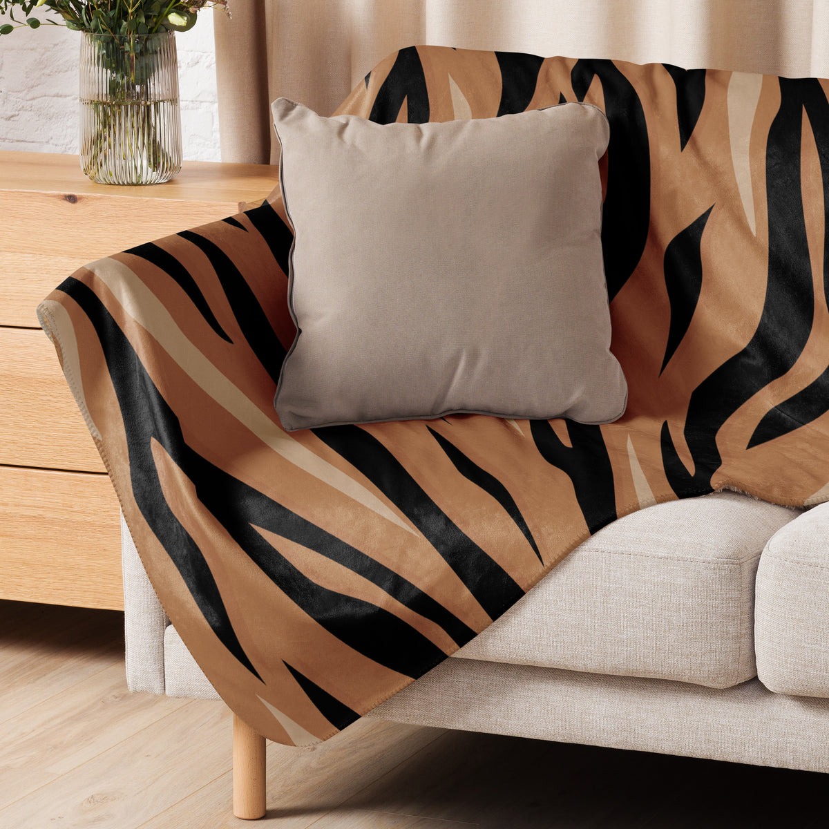 Brown tiger blanket tiger-striped throw blanket with bold black and tan stripes draped over beige sofa