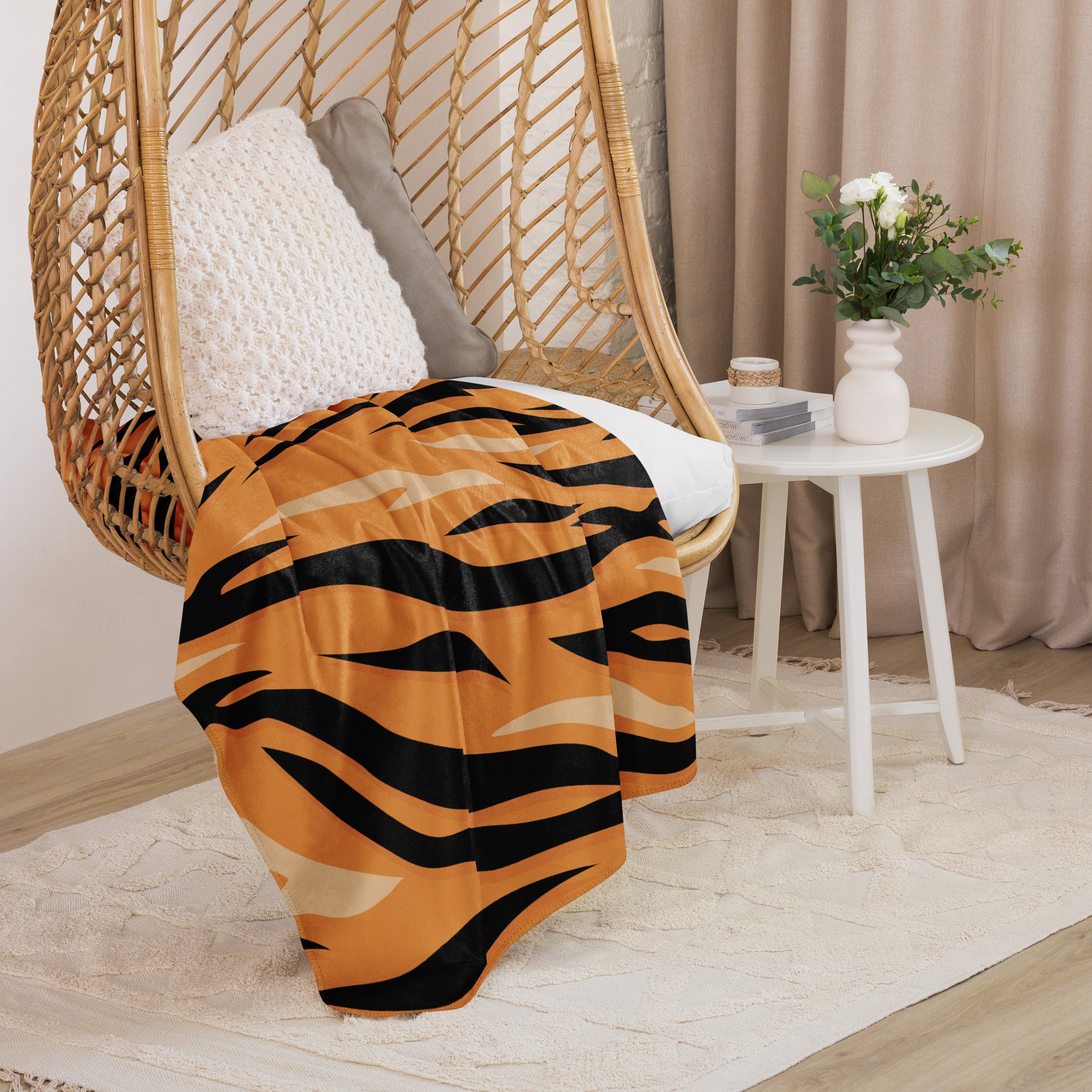 Orange tiger blanket with bold wavy black stripes draped over a woven hanging chair for cozy decor