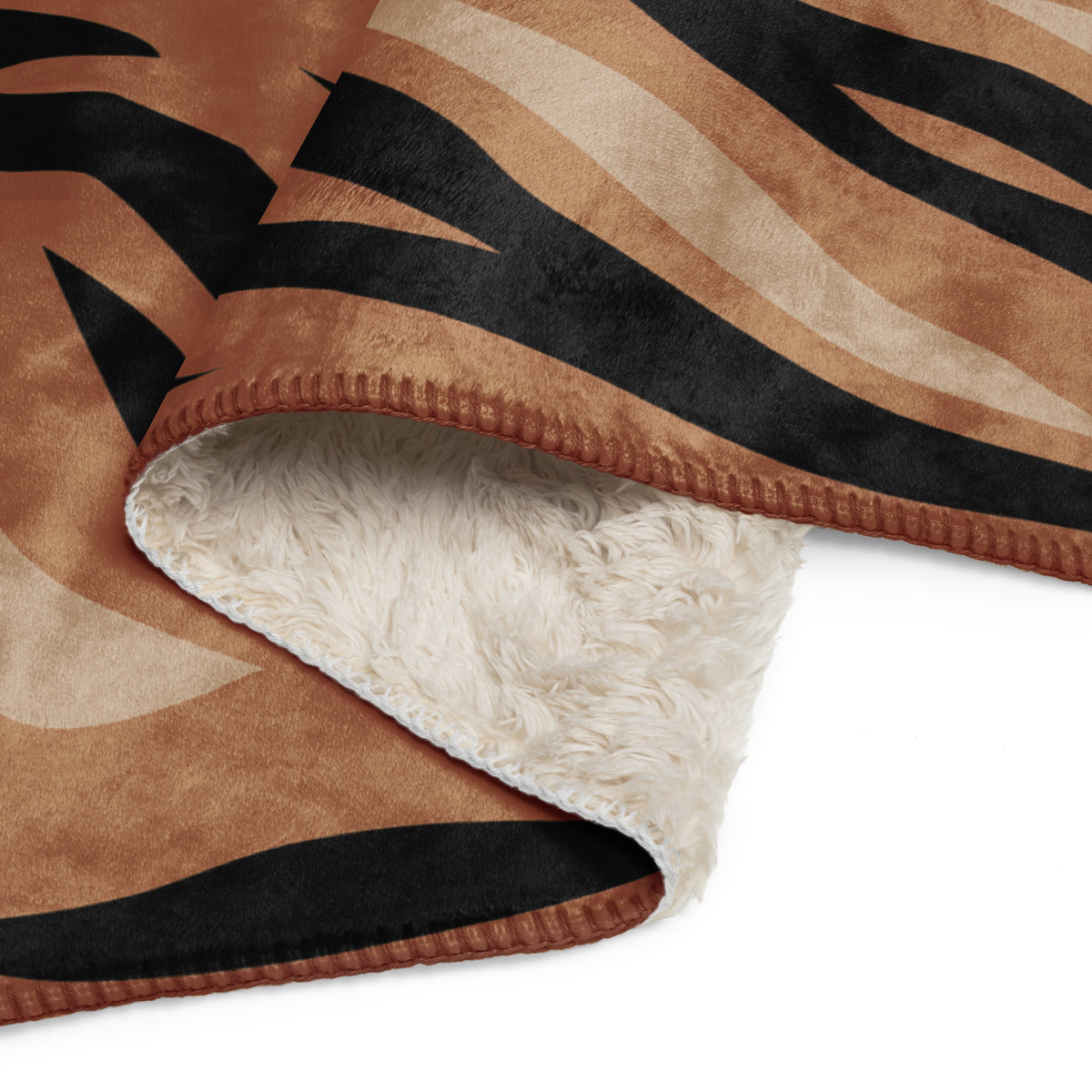 A cozy brown tiger blanket featuring a tan and black tiger-striped fleece with a plush white sherpa lining