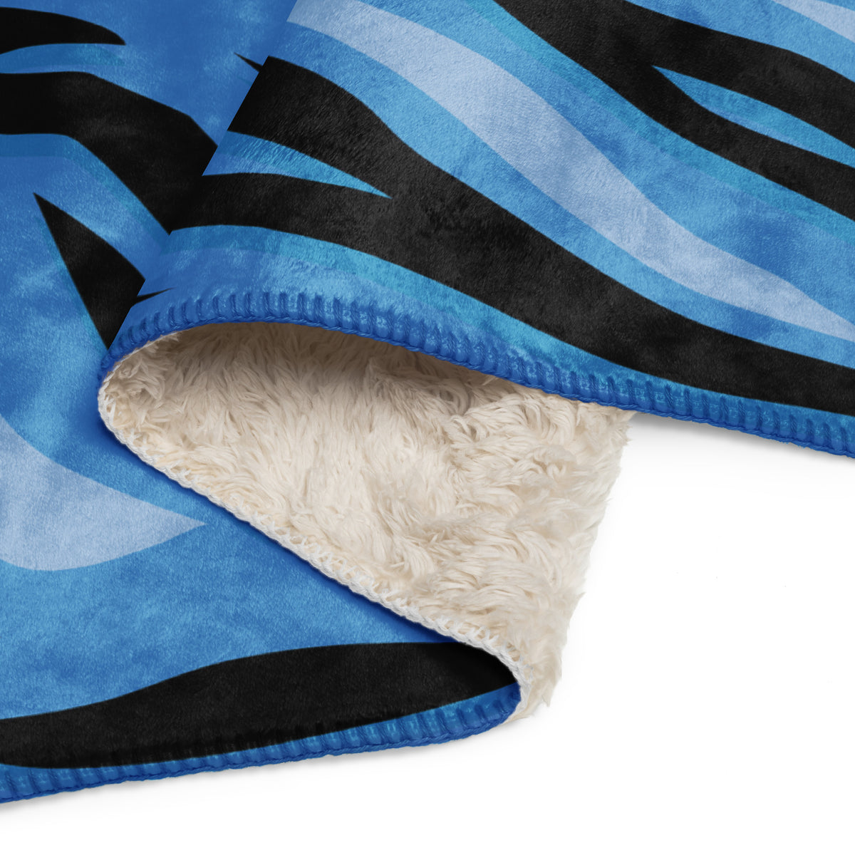 Blue tiger blanket with blue and black zebra-striped fleece and plush cream-colored sherpa lining