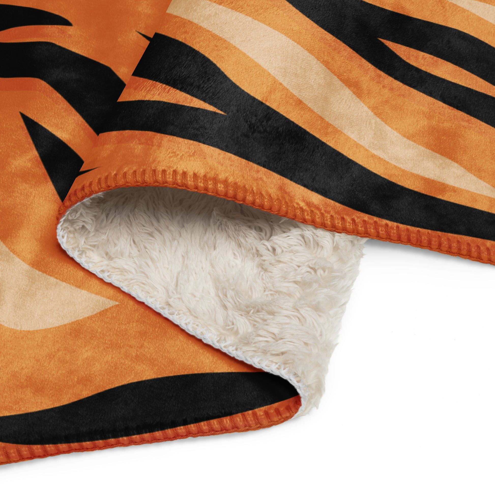 Orange tiger blanket with orange and black tiger stripes and a plush white fleece interior for cozy warmth
