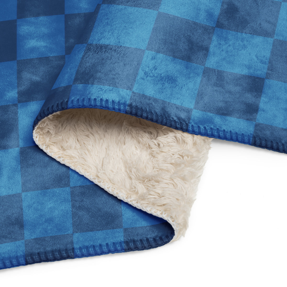 Blue checkered blanket with blue and navy plaid fleece and plush cream-colored sherpa lining for warmth and comfort
