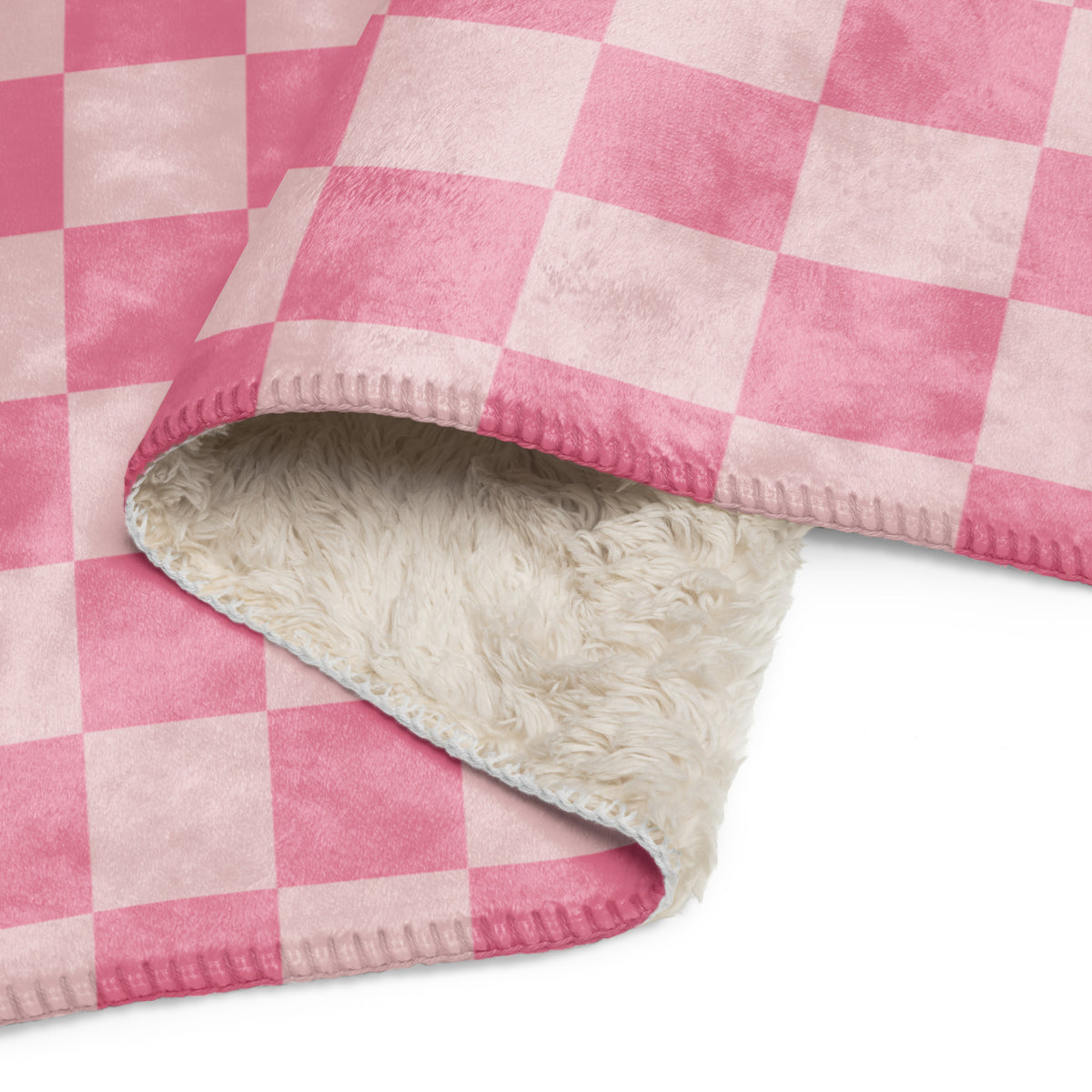 Pink checkered blanket featuring a pink and white checkered fleece with plush cream sherpa lining for warmth