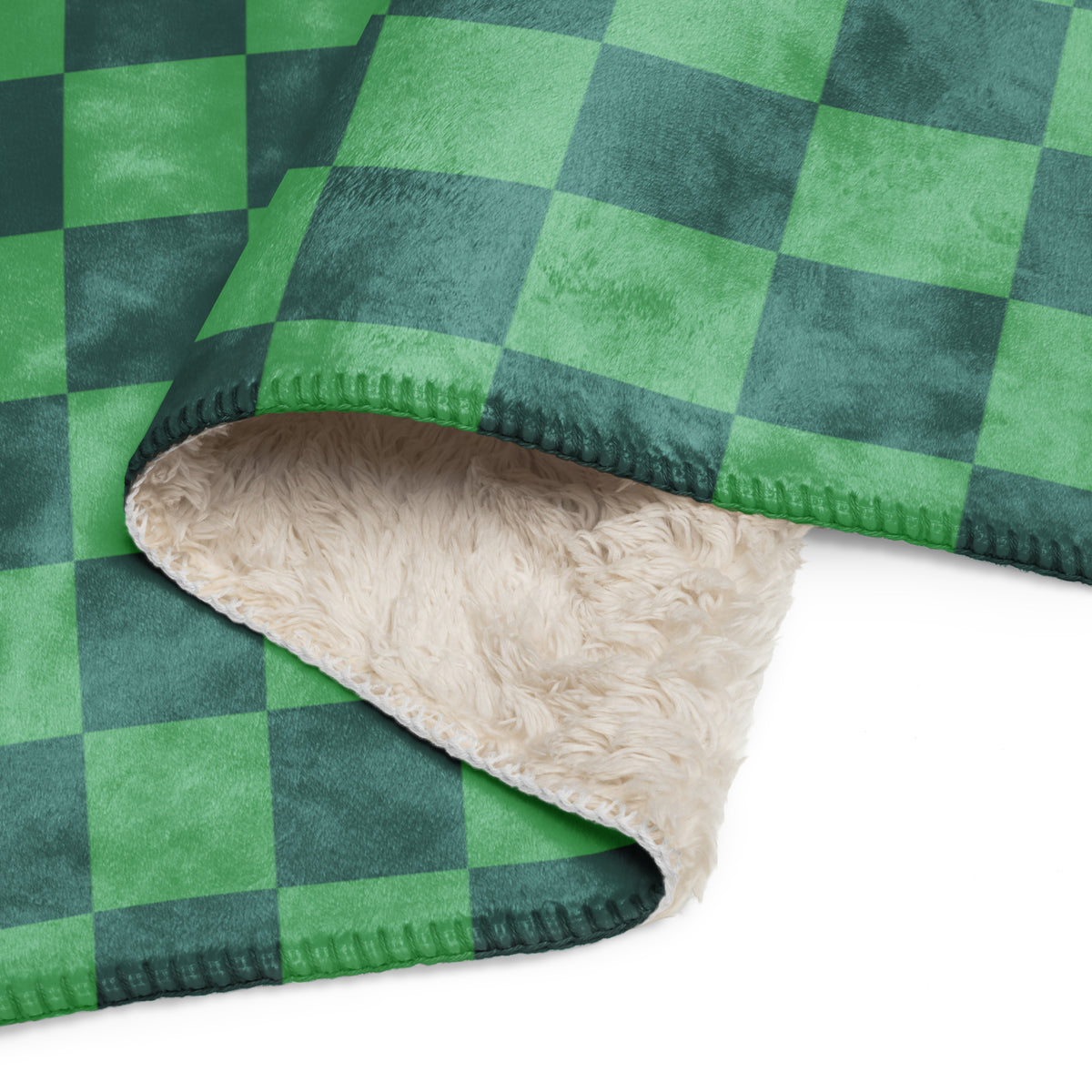 A cozy green checkered fleece blanket with dark green plaid pattern and soft cream sherpa lining
