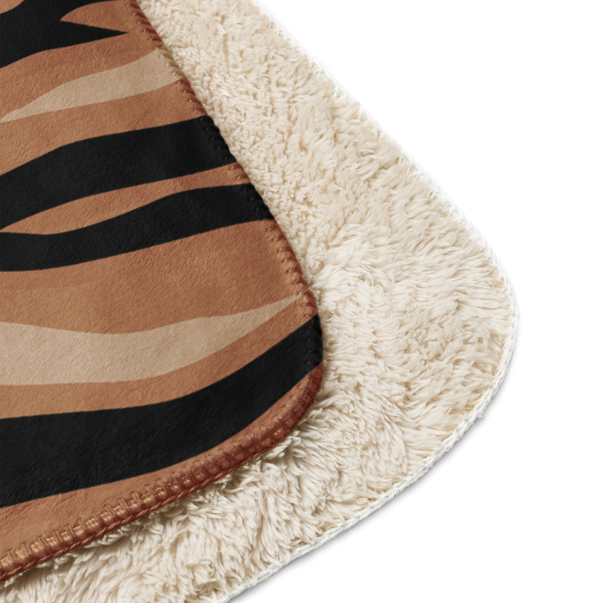 A cozy cream-colored sherpa brown tiger blanket with bold black and tan zebra stripe pattern on the outer surface