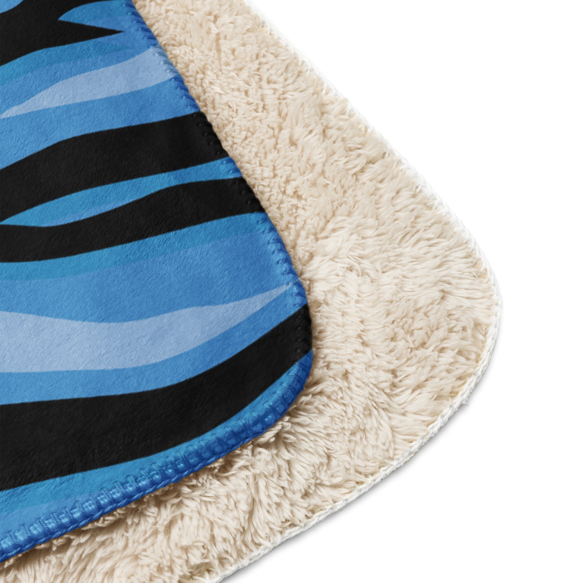 Blue tiger blanket featuring blue and black zebra-striped fleece with a plush cream-colored sherpa lining