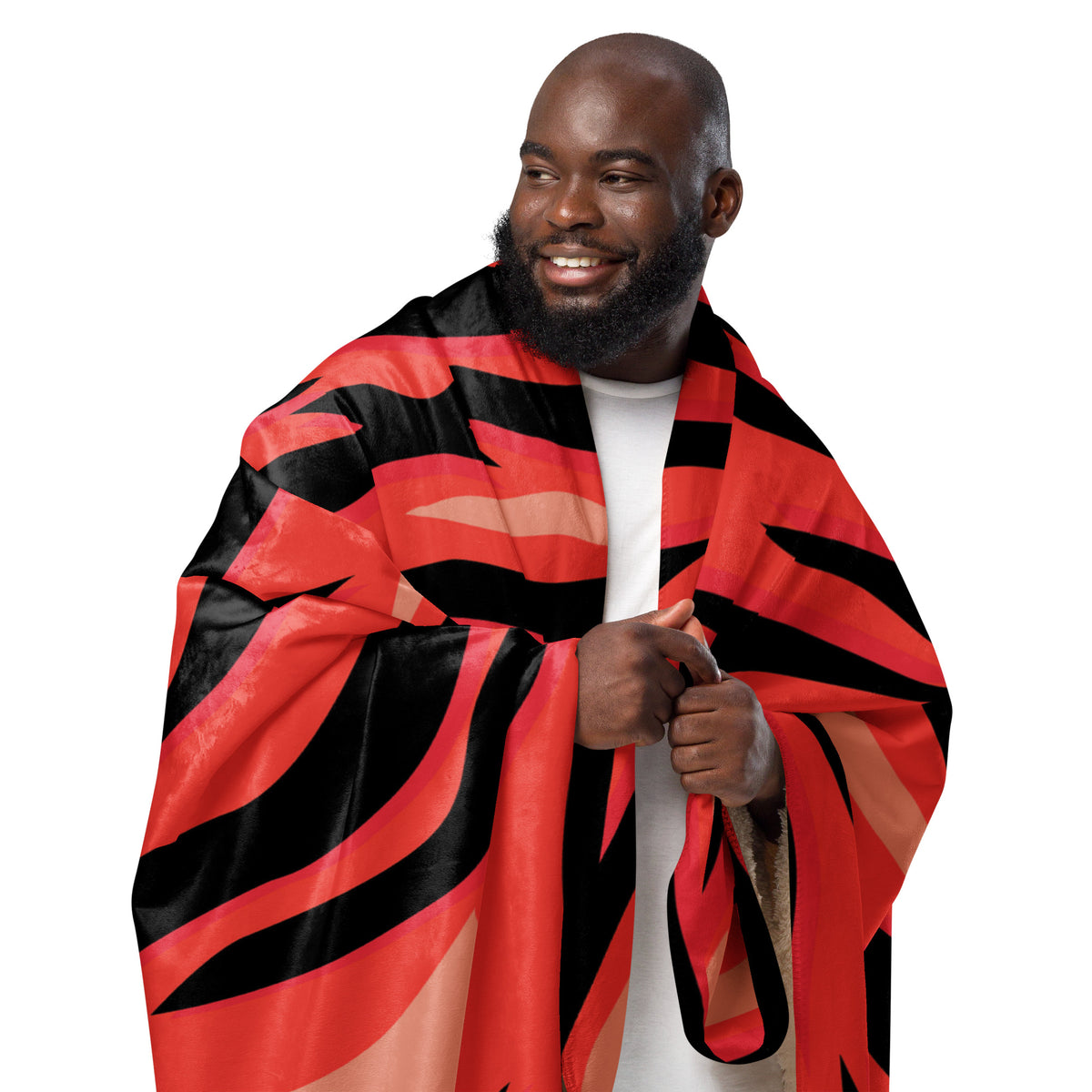 A vibrant red and black striped red tiger blanket with bold tiger patterns draped over a man’s shoulders
