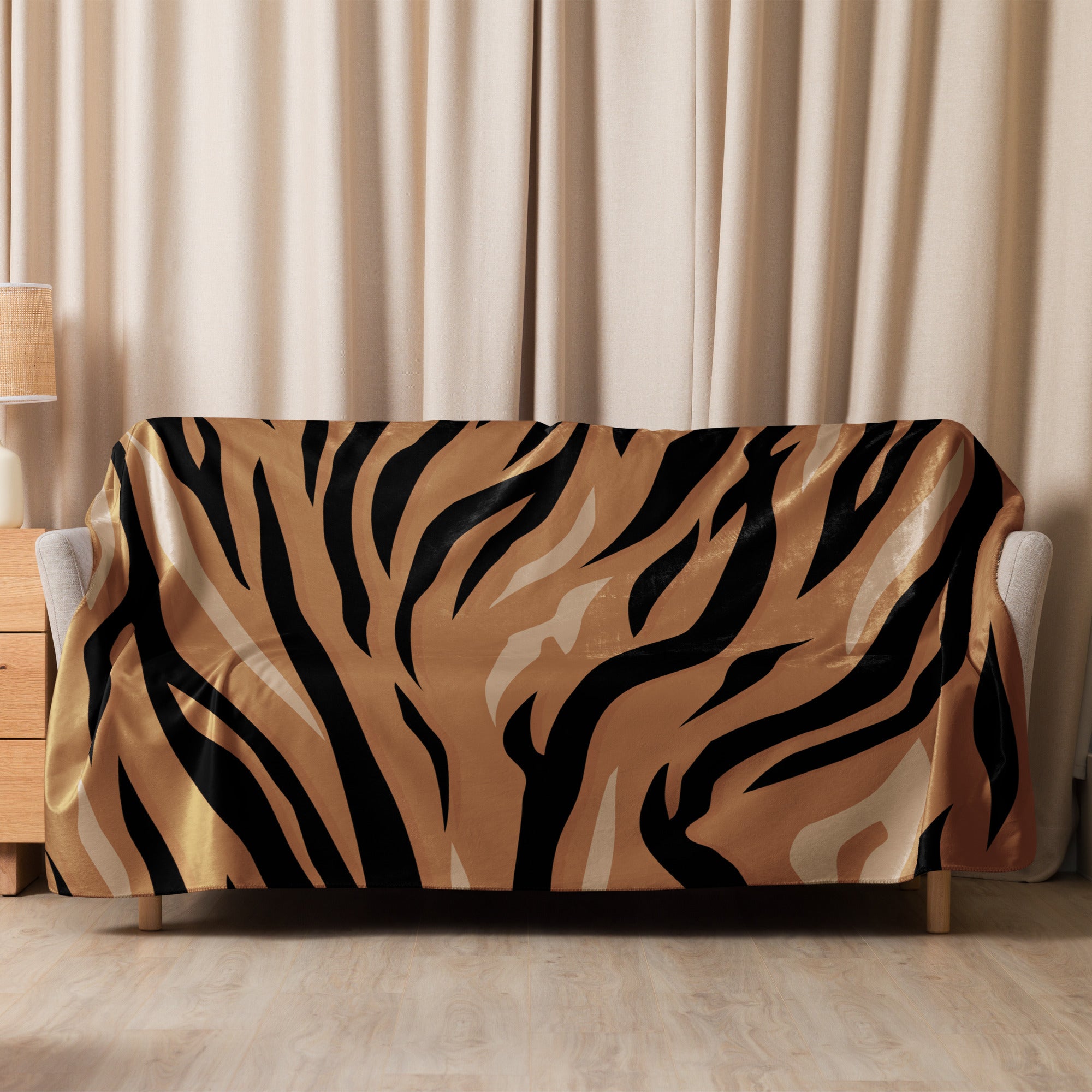 A plush brown tiger blanket with bold black and tan stripes draped over a modern light-colored sofa