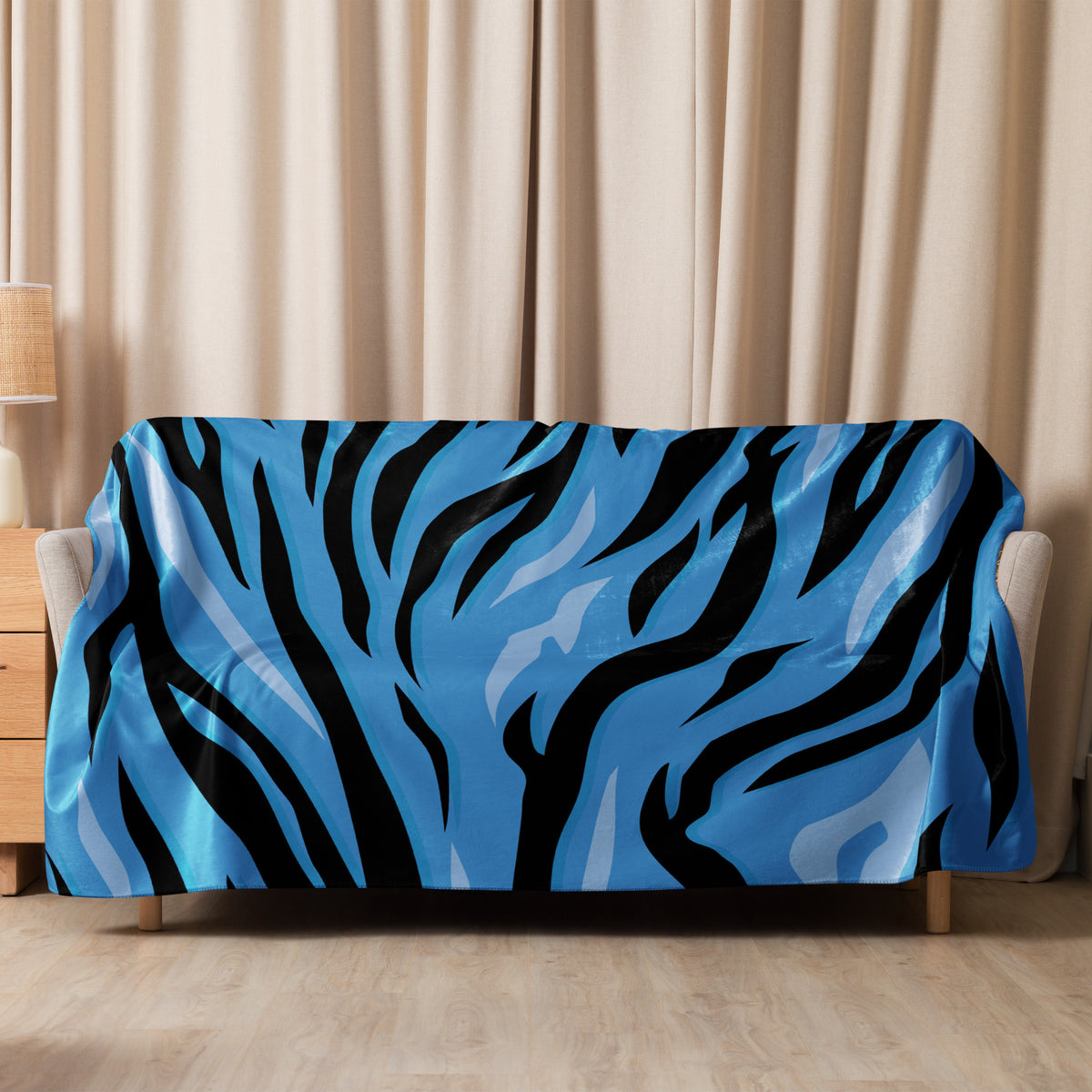 Blue tiger blanket with blue and black zebra stripes draped over a sofa for cozy home decor