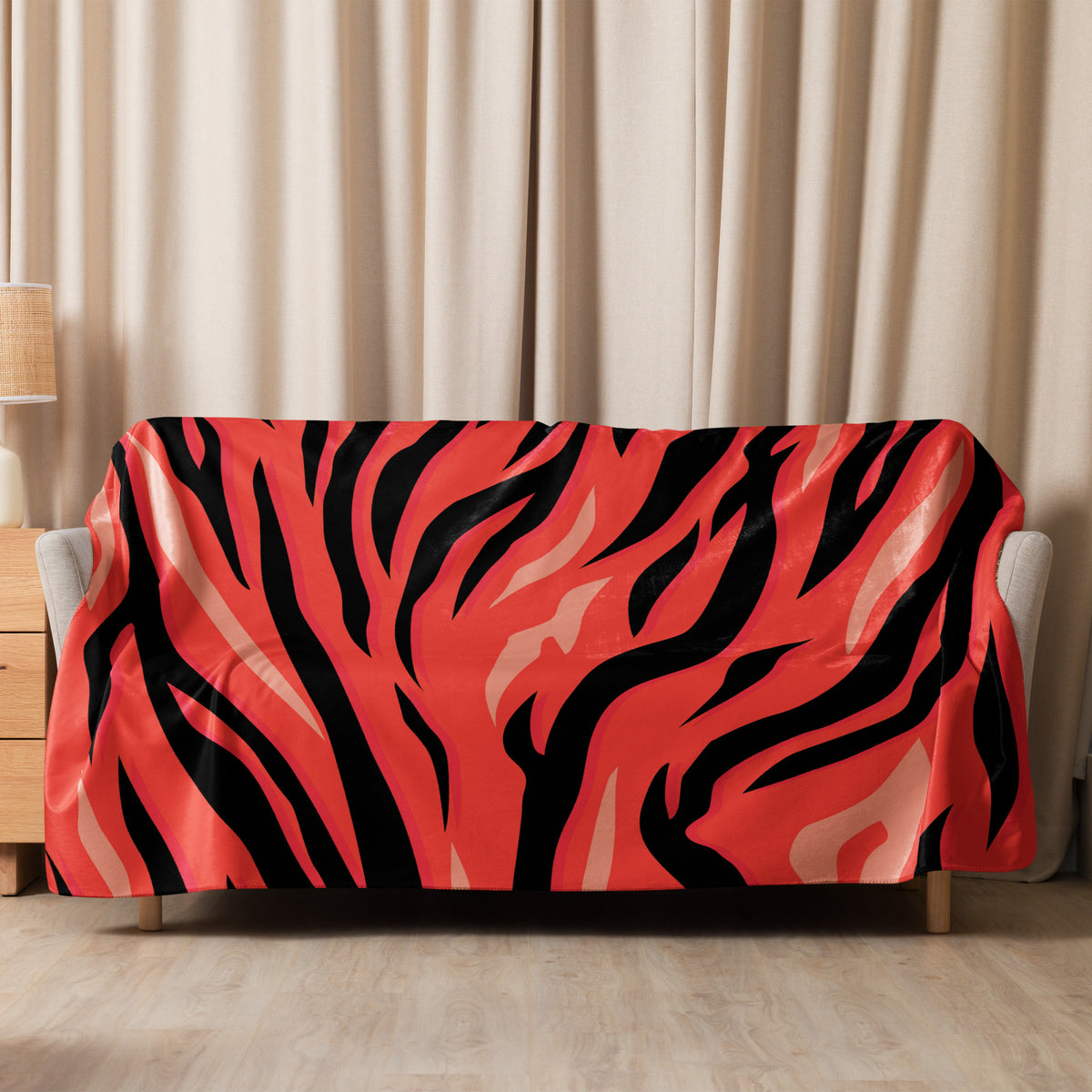 Red tiger blanket with vibrant coral and black tiger stripe pattern draped over a sofa for cozy use